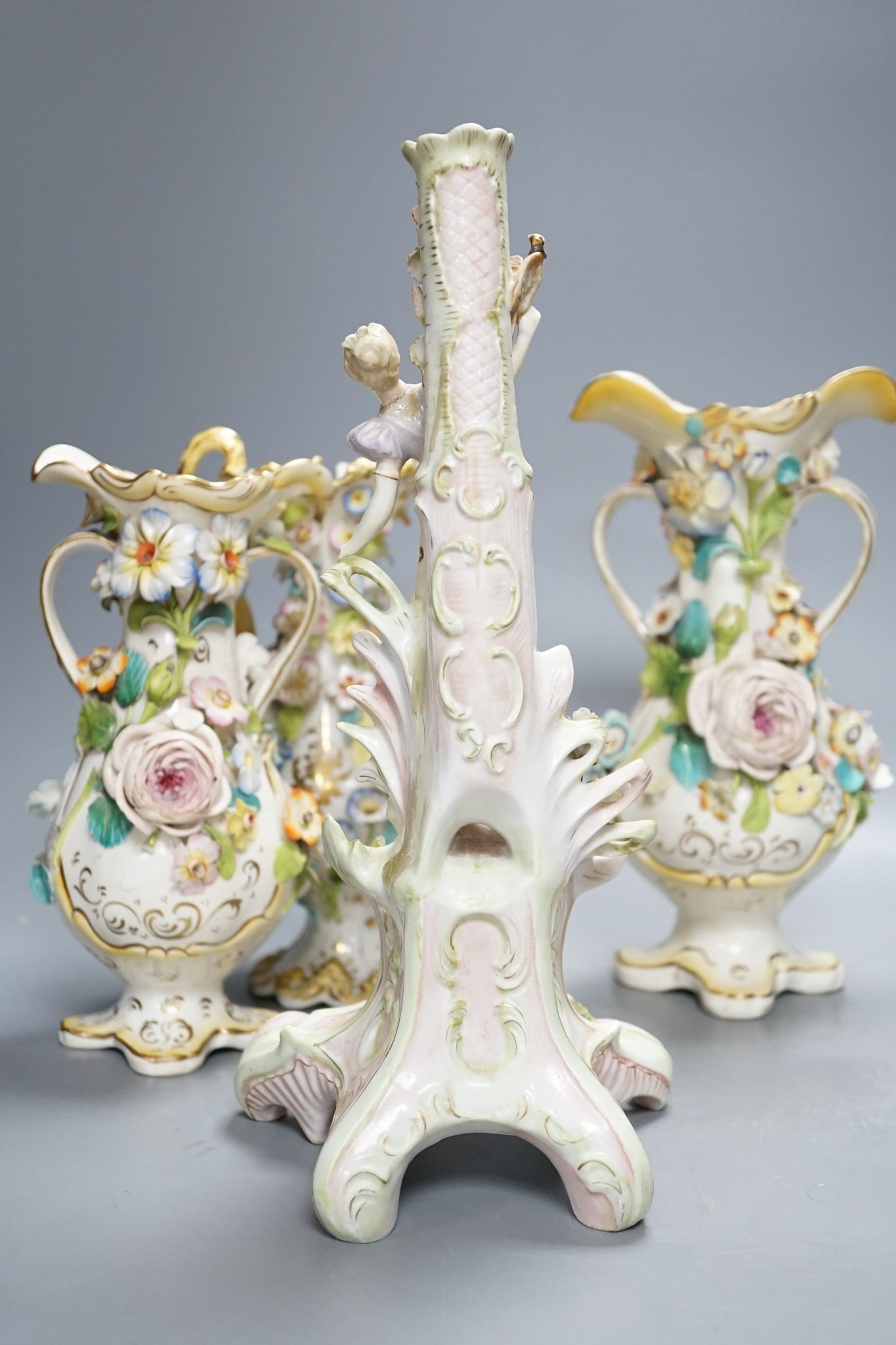 Four Coalport-type floral encrusted vases and a figural candlestick, 32cm